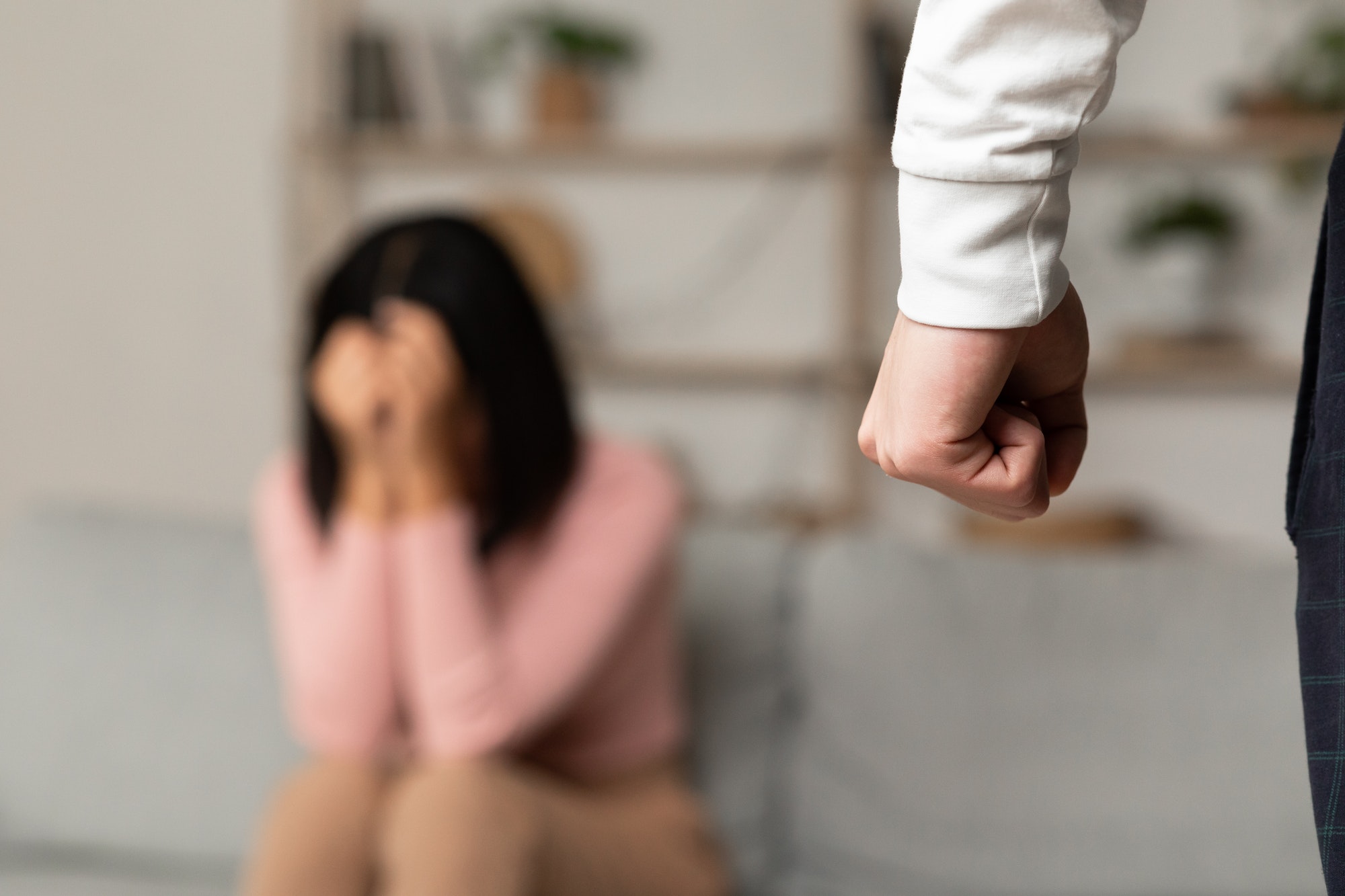 Domestic Abuse, Angry Asian Husband Clenching Fist Threatening Wife Indoors