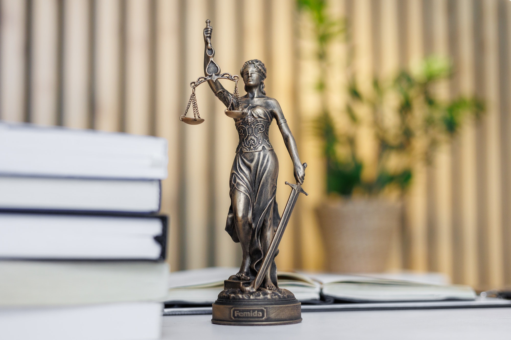 statuette of Themis, the goddess of justice, stands on a table in the office of a law firm or