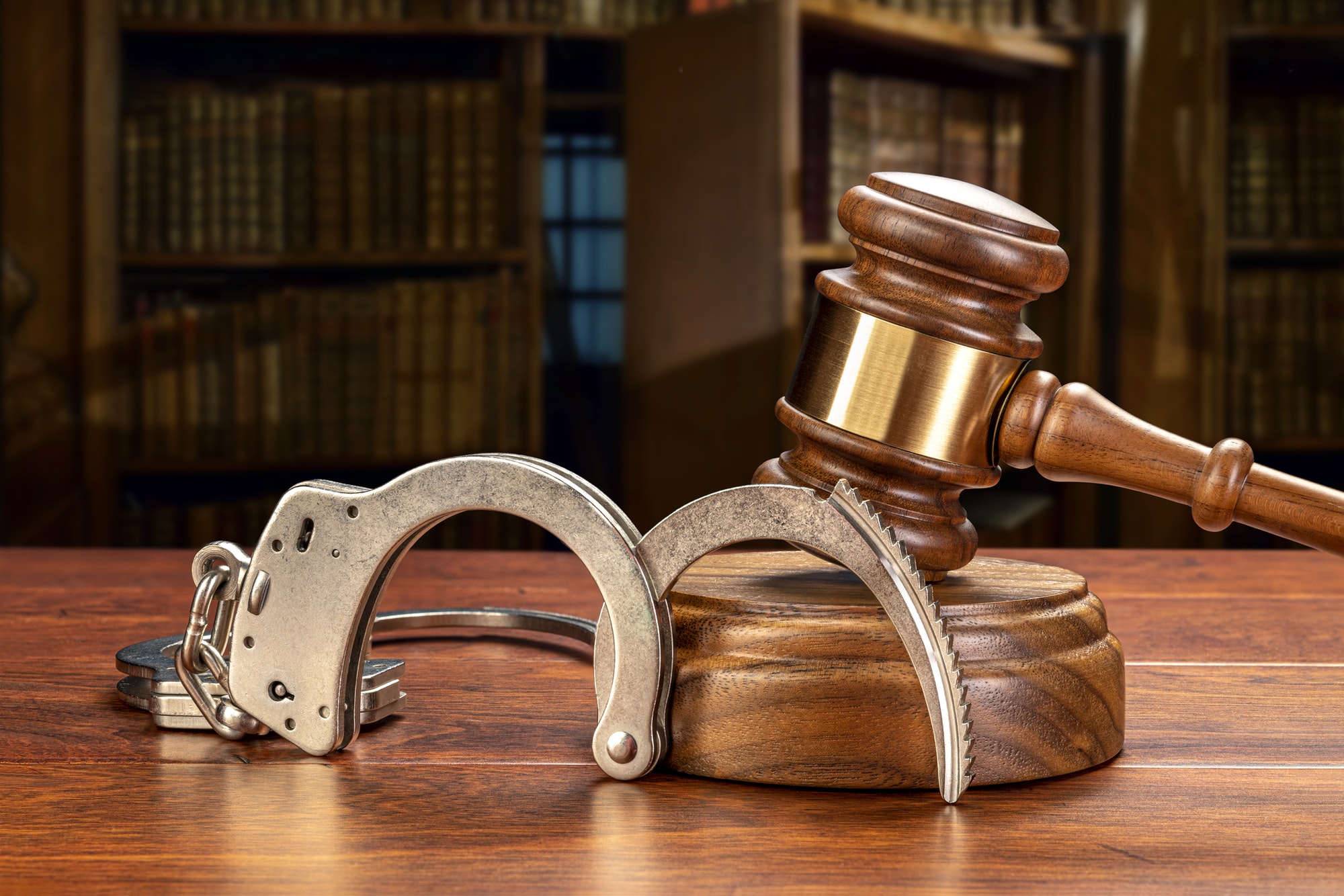 Handcuffs and gavel in law library